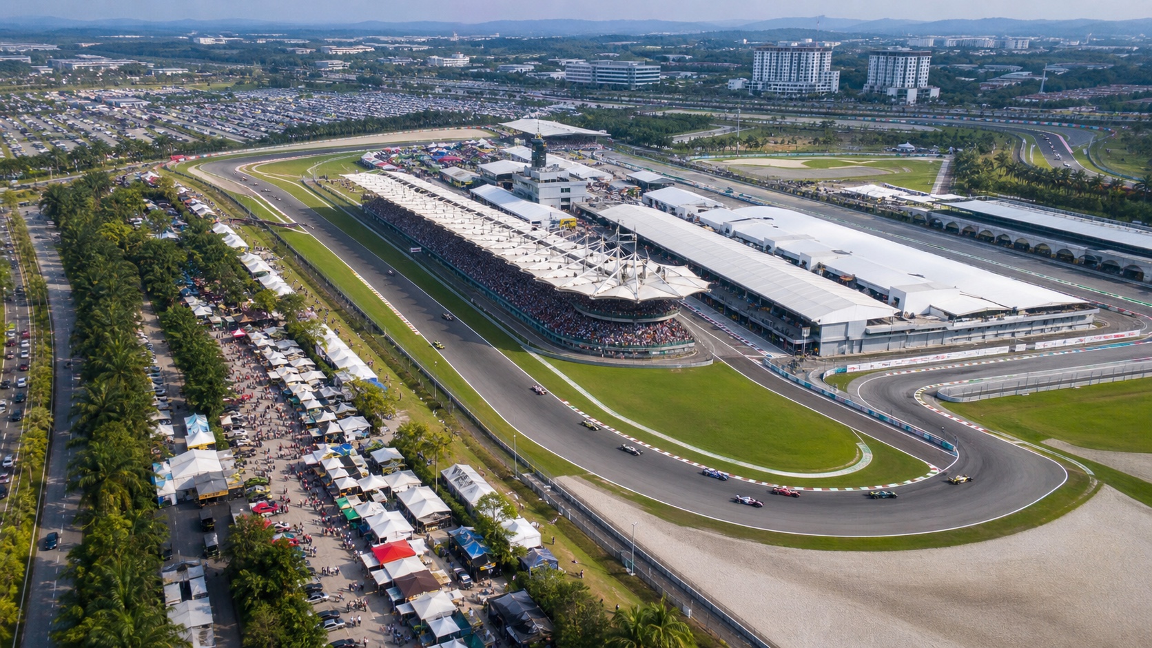 Aerial view of an unbranded open-wheel race at a Sepang motorsport circuit with local vendor areas